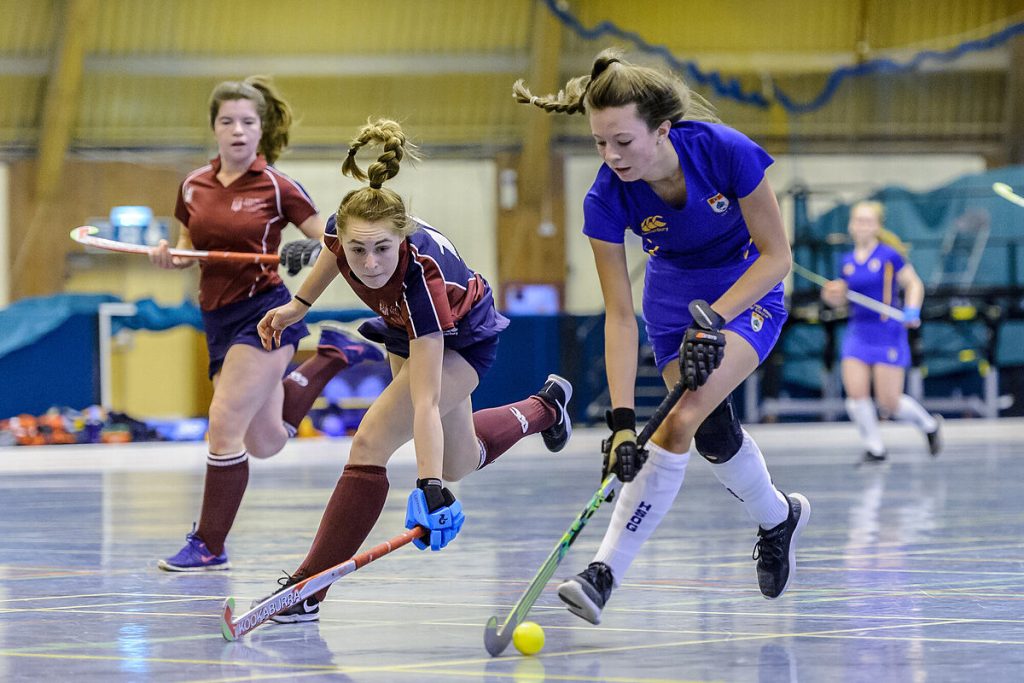Young players during an indoor hockey session in a sports hall