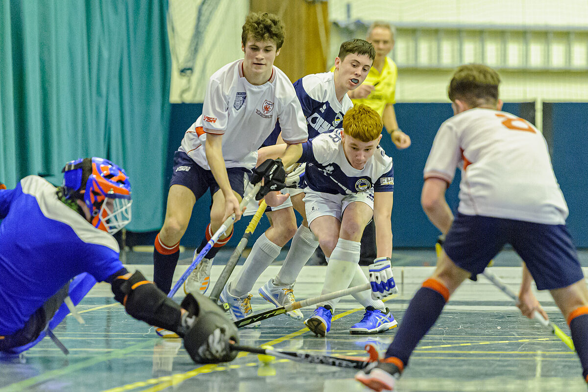 Two players challenging for the ball during an indoor hockey match
