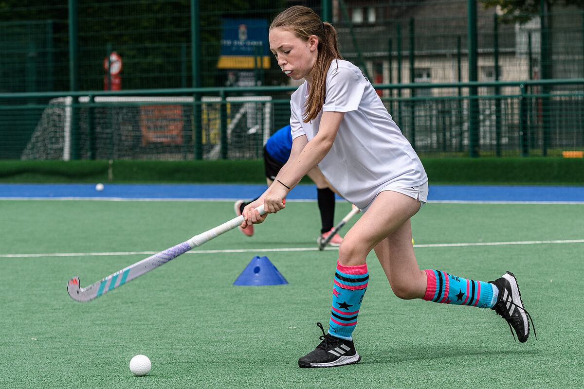 A young player practising her hockey technique at a Spider Hockey camp