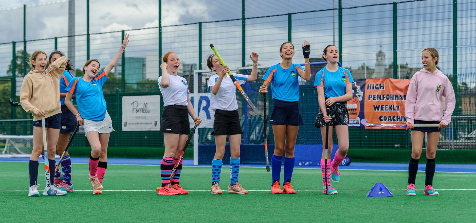 Spider Hockey players celebrating on the pitch at the High School of Glasgow